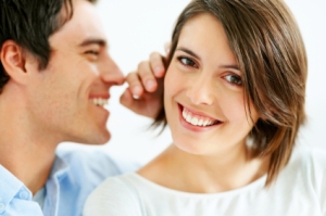 Closeup portrait of a handsome young man whispering in his wife ear